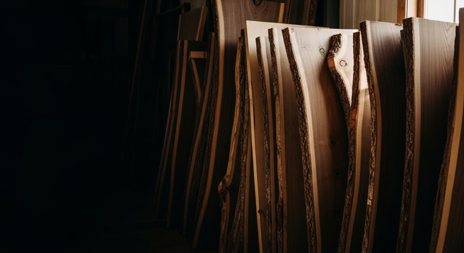 Live edge hardwood slabs leaning in the lumber rack